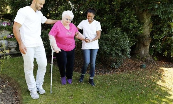 Équipe infirmière accompagnant une patiente à la marche